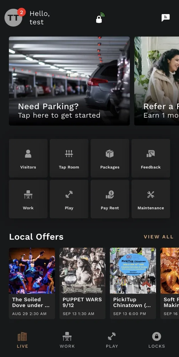 The STAK resident app's LIVE tab on a phone: a promo carousel, then a grid of eight service tiles — Visitors, Tap Room, Packages, Feedback, Work, Play, Pay Rent and Maintenance — above a row of local offers, with LIVE, WORK, PLAY and LOCKS along the bottom.